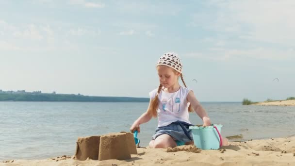 Kinderen spelen op het strand aan de rivier op een zonnige dag — Stockvideo