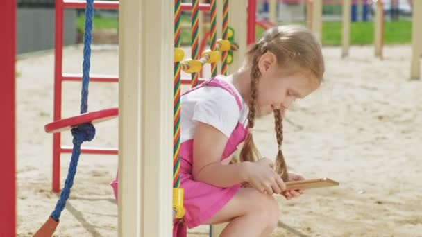 Niña preescolar utilizar dispositivos móviles al aire libre — Vídeos de Stock