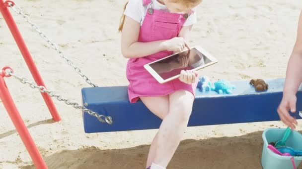 I bambini usano un tablet per computer, camminano nel parco giochi — Video Stock