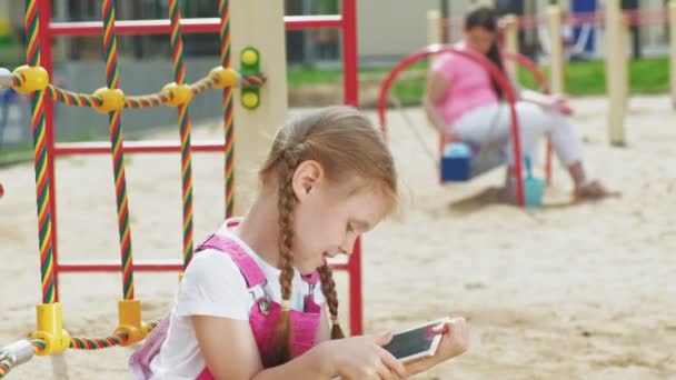 Los niños usan una tableta de computadora, caminan en el patio de recreo — Vídeos de Stock
