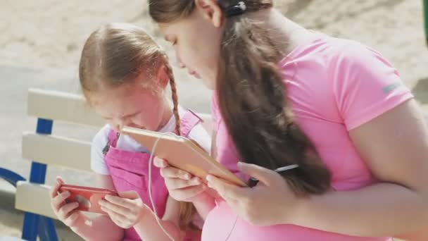 Adolescente fille préscolaire en utilisant des appareils mobiles à l'extérieur — Video