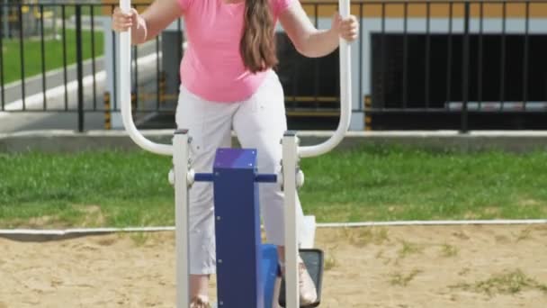 Teenager-Mädchen auf dem Freigelände mit Trainingsgeräten. Gesunder Lebensstil — Stockvideo