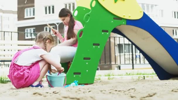 Children use a computer tablet, walk on the playground — Stock Video