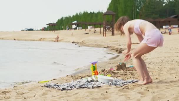 Madre con su hija en un picnic junto al río en un día soleado — Vídeos de Stock