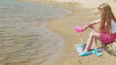 Güneşli bir günde nehir kıyısında ki sahilde oynayan çocuklar