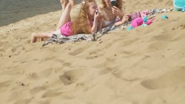 Nehir kıyısındaki anne ve kızı dondurma yiyor. Açık hava rekreasyon