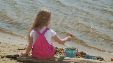 Güneşli bir günde nehir kıyısında ki sahilde oynayan çocuklar