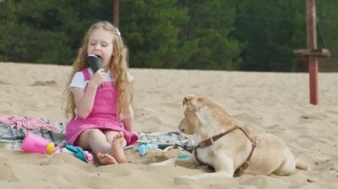 Kız dondurma yiyor ve açık havada köpek besler.