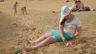  Kız nehir kıyısında bir kum dansı inşa ediyor.