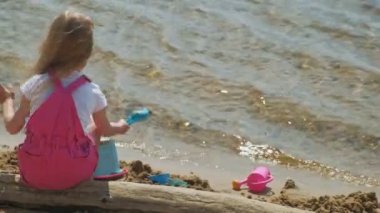 Güneşli bir günde nehir kıyısında ki sahilde oynayan çocuklar