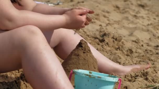 Lány épít egy homokvárat a folyóparton — Stock videók