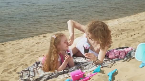 Mutter und Tochter am Flussufer essen Eis. Freizeitgestaltung im Freien — Stockvideo