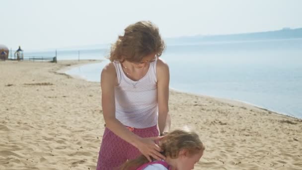 Mamãe está escovando sua filha ao ar livre, verão — Vídeo de Stock