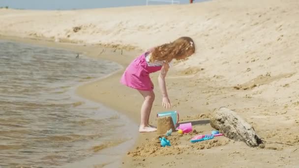 Kinder spielen an einem sonnigen Tag am Strand am Fluss — Stockvideo