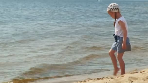 Preschool girl walks by the river on a summer day — Stock Video