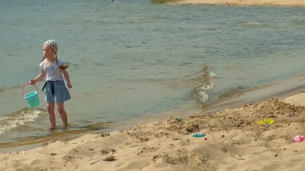 Une fille d'âge préscolaire se promène au bord de la rivière un jour d'été — Video