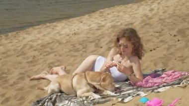 Nehrin kıyısında genç bir kadın dondurma yiyor. Açık hava rekreasyon