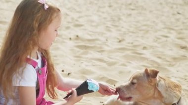 Kız dondurma yiyor ve açık havada köpek besler.