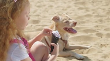 Kız dondurma yiyor ve açık havada köpek besler.