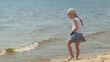 Okul öncesi kız bir yaz gününde nehir tarafından yürüyor