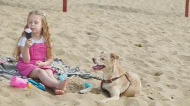 Kız dondurma yiyor ve açık havada köpek besler.
