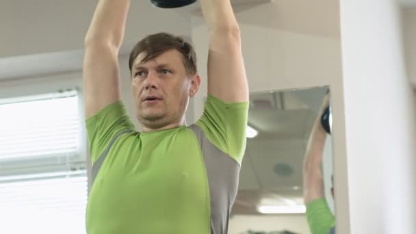 Man doet bankdrukken met dumbbells in fitness studio — Stockvideo