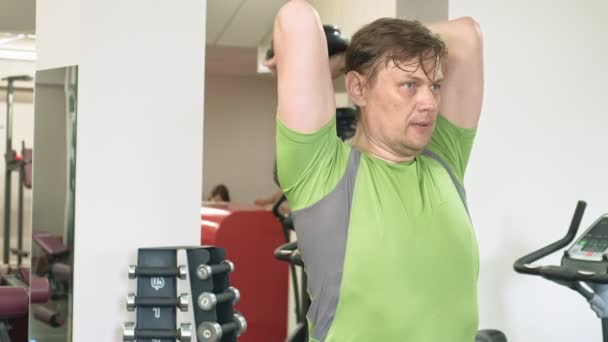 Hombre haciendo press de banca con pesas en gimnasio — Vídeo de stock