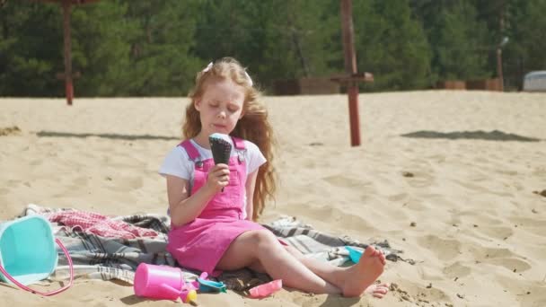 Girl eats ice cream outdoors. — Stock Video