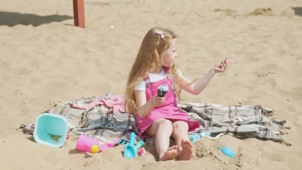 Lány eszik fagylaltot, és táplálja a kutyát a szabadban. — Stock videók