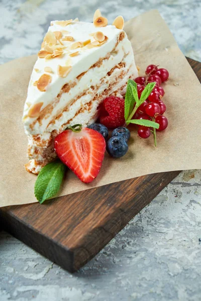 Tarta de merengue de fresa con pétalos de almendra, en el periódico —  Fotos de Stock