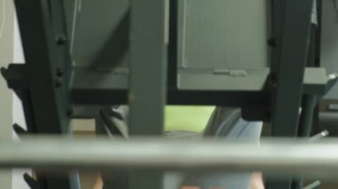 Spor salonunda simülatörde bacak presleri yapan aşırı kilolu bir adam. Fitness eğitimi. Sağlıklı yaşam tarzı kavramı