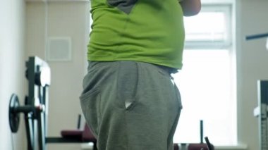 Kilolu adam bir halter için bir ağırlık diski ile squats ile çömelme yok. Fitness eğitimi. Sağlıklı yaşam tarzı kavramı