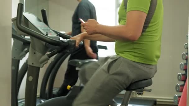 Hombre en bicicleta estática en el gimnasio. concepto de estilo de vida saludable — Vídeos de Stock