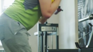 Kilolu adam bir halter için bir ağırlık diski ile squats ile çömelme yok. Fitness eğitimi. Sağlıklı yaşam tarzı kavramı