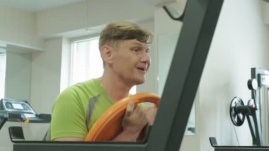Kilolu adam bir halter için bir ağırlık diski ile squats ile çömelme yok. Fitness eğitimi. Sağlıklı yaşam tarzı kavramı