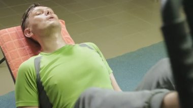 Spor salonunda simülatörde bacak presleri yapan aşırı kilolu bir adam. Fitness eğitimi. Sağlıklı yaşam tarzı kavramı