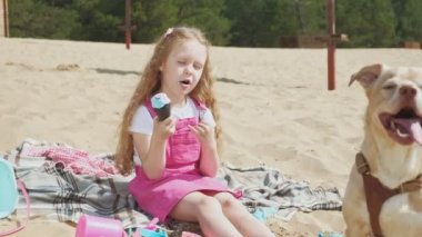 Kız dondurma yiyor ve açık havada köpek besler.