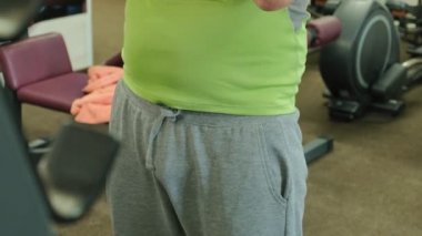 Kilolu adam bir halter için bir ağırlık diski ile squats ile çömelme yok. Fitness eğitimi. Sağlıklı yaşam tarzı kavramı