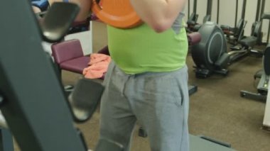 Kilolu adam bir halter için bir ağırlık diski ile squats ile çömelme yok. Fitness eğitimi. Sağlıklı yaşam tarzı kavramı