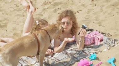 Nehir kıyısındaki anne ve kızı dondurma yiyor. Açık hava rekreasyon