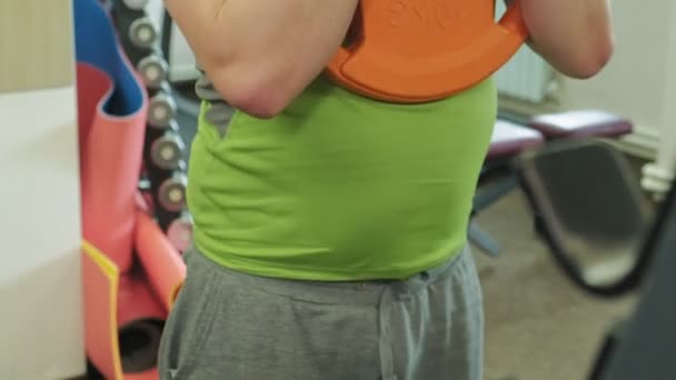 Nadváha muže se squaty s hmotnostním diskem pro zvoneček. Fitness trénink. Koncepce zdravého životního stylu — Stock video