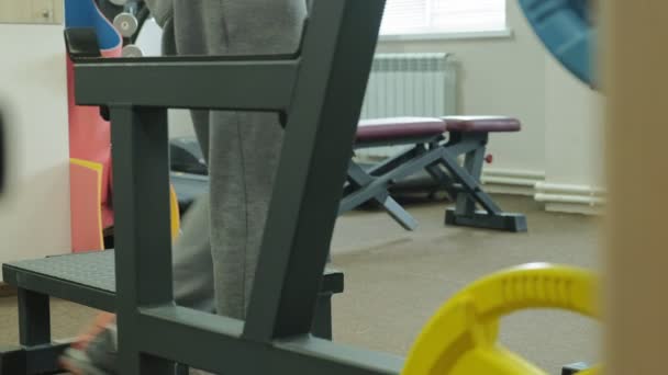 De overgewicht man doet squats met squats met een gewicht schijf voor een barbell. Fitness training. Gezond lifestyle concept — Stockvideo