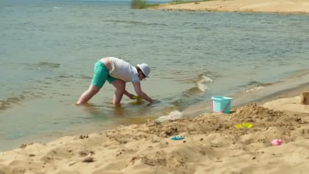 Kinder spielen an einem sonnigen Tag am Strand am Fluss — Stockvideo