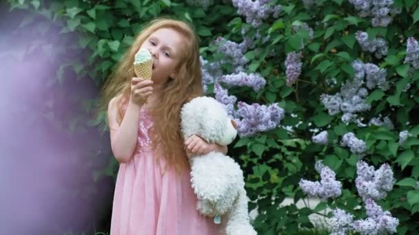 Une petite fille mange de la glace dehors. Été — Video