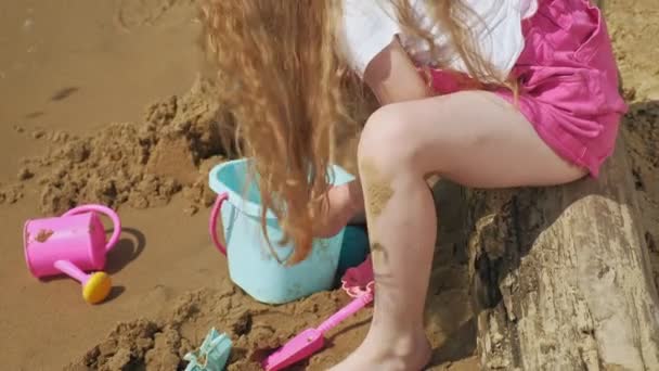Діти грають на пляжі біля річки в сонячний день — стокове відео