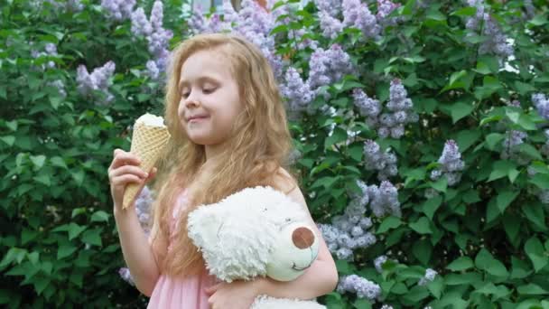 Mała dziewczynka zjada lody na świeżym powietrzu. Letnich — Wideo stockowe