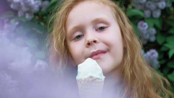 Liten flicka äter glass utomhus. Sommaren — Stockvideo