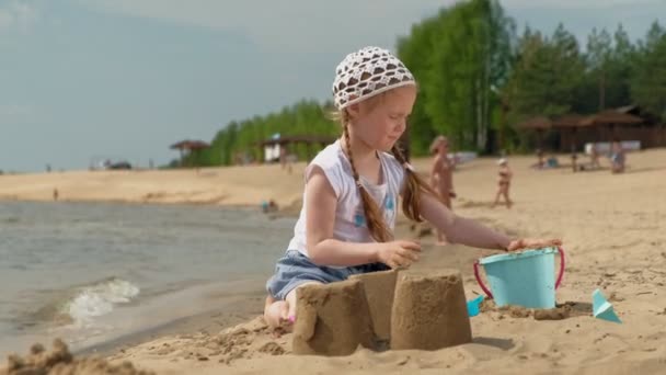 Niños jugando en la playa junto al río en un día soleado — Vídeos de Stock