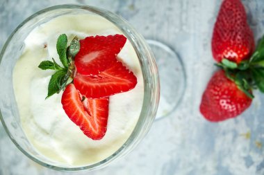 Cam vazoda çilekli dondurma. Gri dokulu arka plan. Tatlı