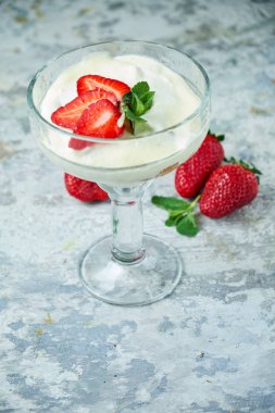 Cam vazoda çilekli dondurma. Gri dokulu arka plan. Tatlı